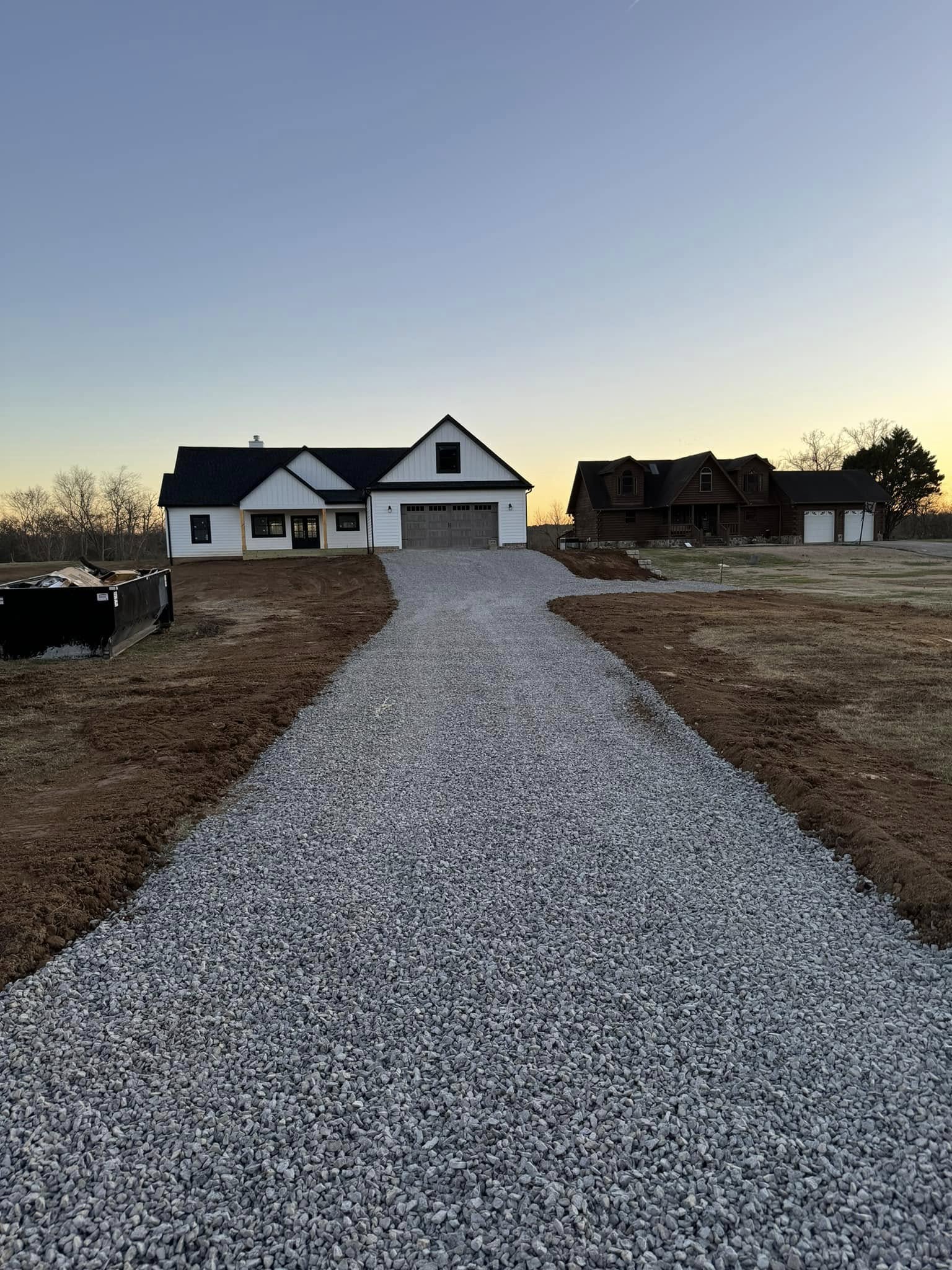 Fresh gravel driveway leading to a new home