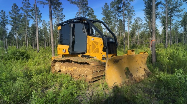 Tracked clearing machine working in a wooded property