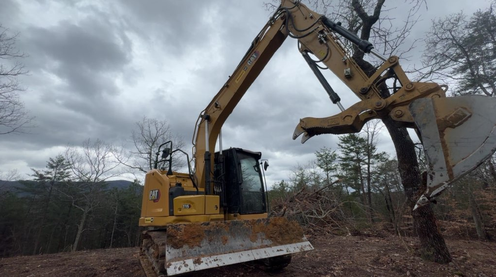 Excavator clearing a wooded Southeast Land Services jobsite